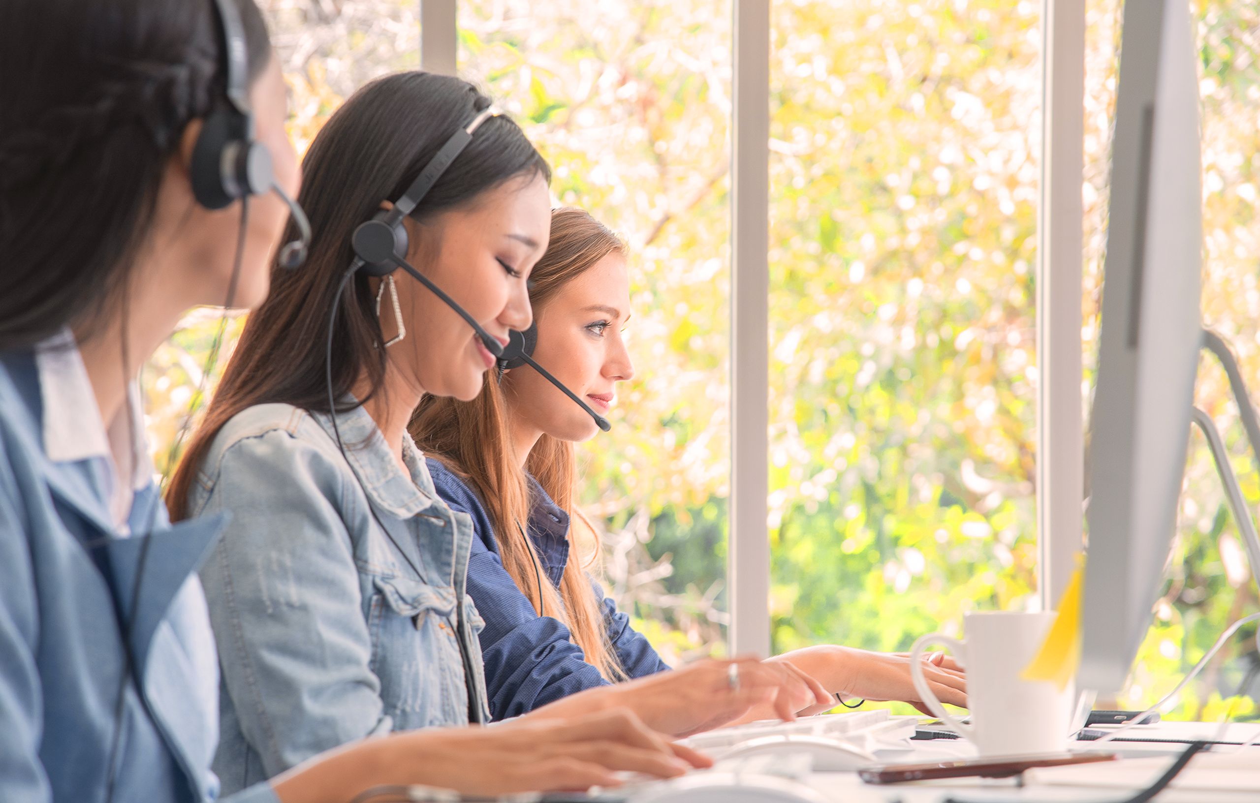 Ομάδα εργαζομένων χρησιμοποιεί headsets σε σύγχρονο περιβάλλον επικοινωνίας